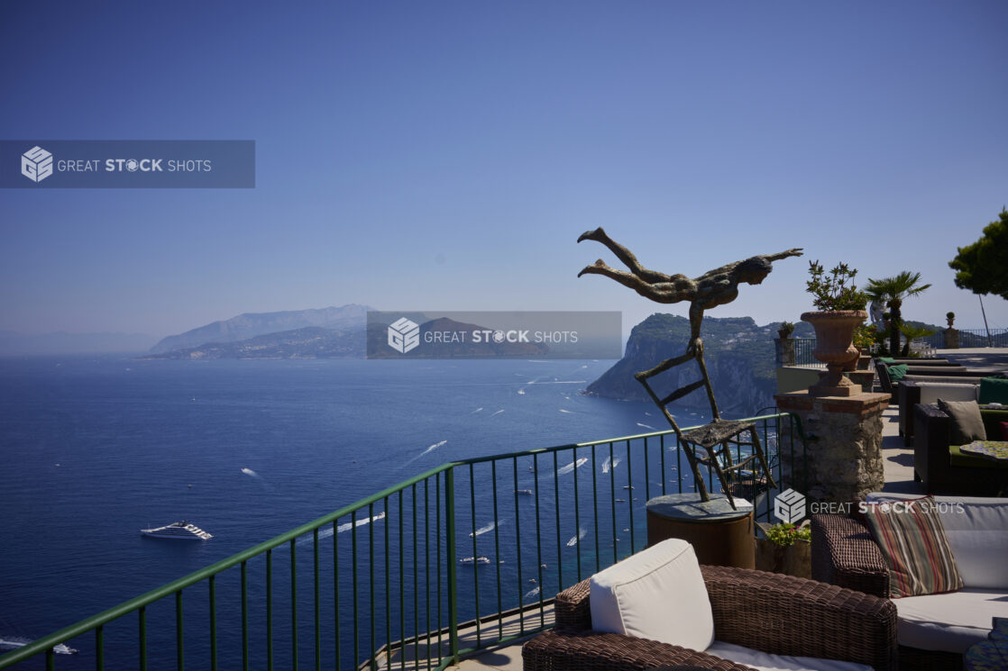 Bronze Art Statue on Outdoor Terrace overlooking Italian Coastline with beautiful Cliffs in the background surrounded by perfectly blue ocean