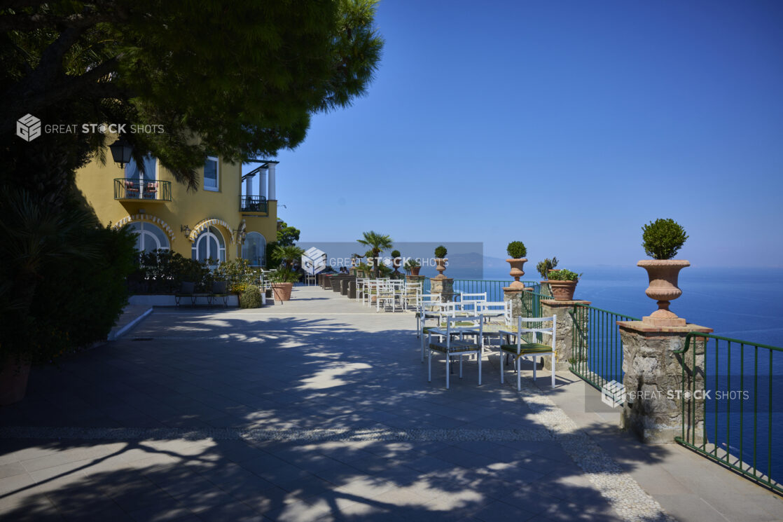 Beautiful outdoor cafe on the top of a cliff in Capri, Italy with tables and greenery