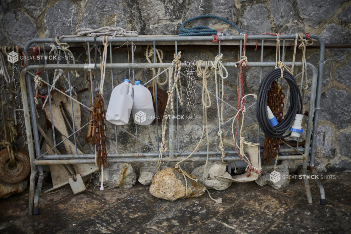 Fishing gear/ropes tied to a barrier against a stone wall