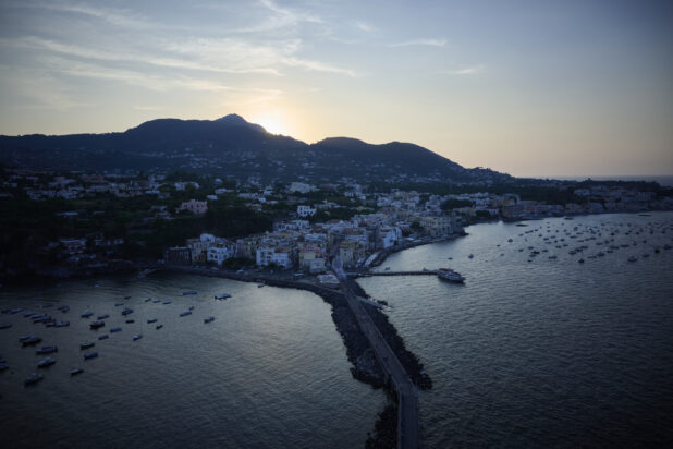 Sunset Dusk Wide Landscape Portrait of Ischia, Italian Costal Town with Mountains in background, boats in harbour and a colourful sky