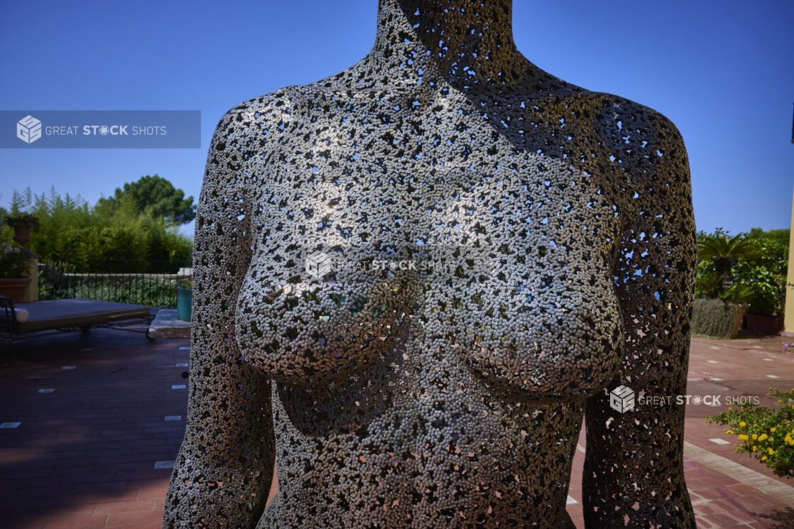 Up close view of "Meditation 1039" by Seo Young Deok on a brick walkway in Capri, Italy, flowers and the Mediterranean sea in the background