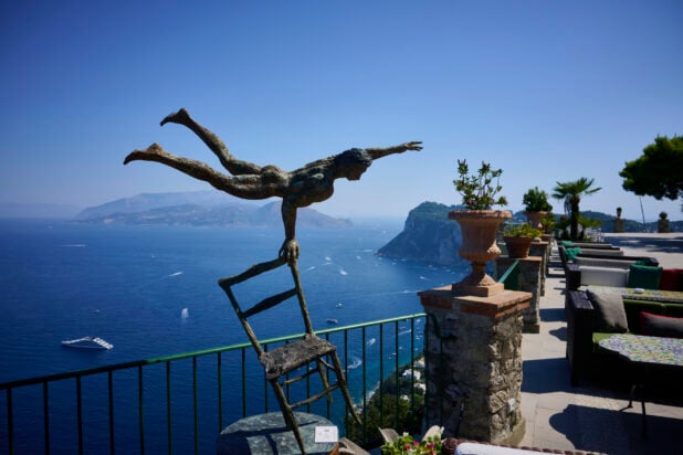 Bronze Art Statue on Outdoor Terrace overlooking Italian Coastline with beautiful Cliffs in the background surrounded by perfectly blue ocean