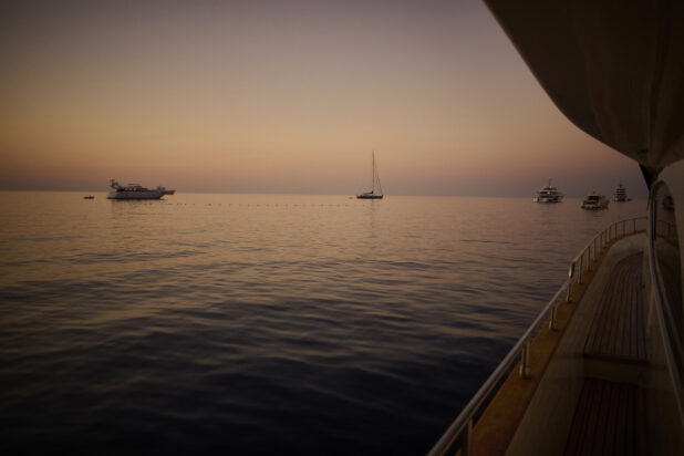 View of sunset and other boats/yachts from a yacht deck