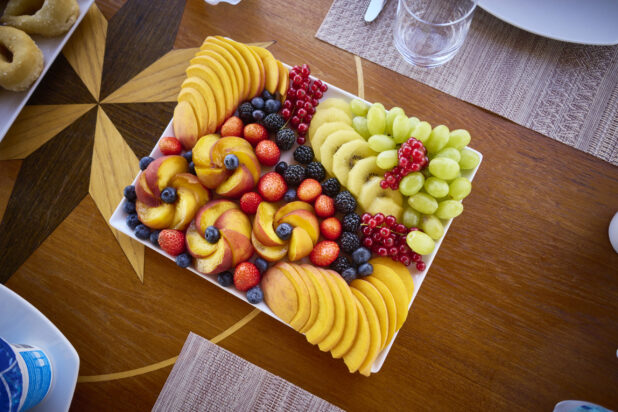 Artisanal fresh fruit platter on a beautiful inlaid wood table