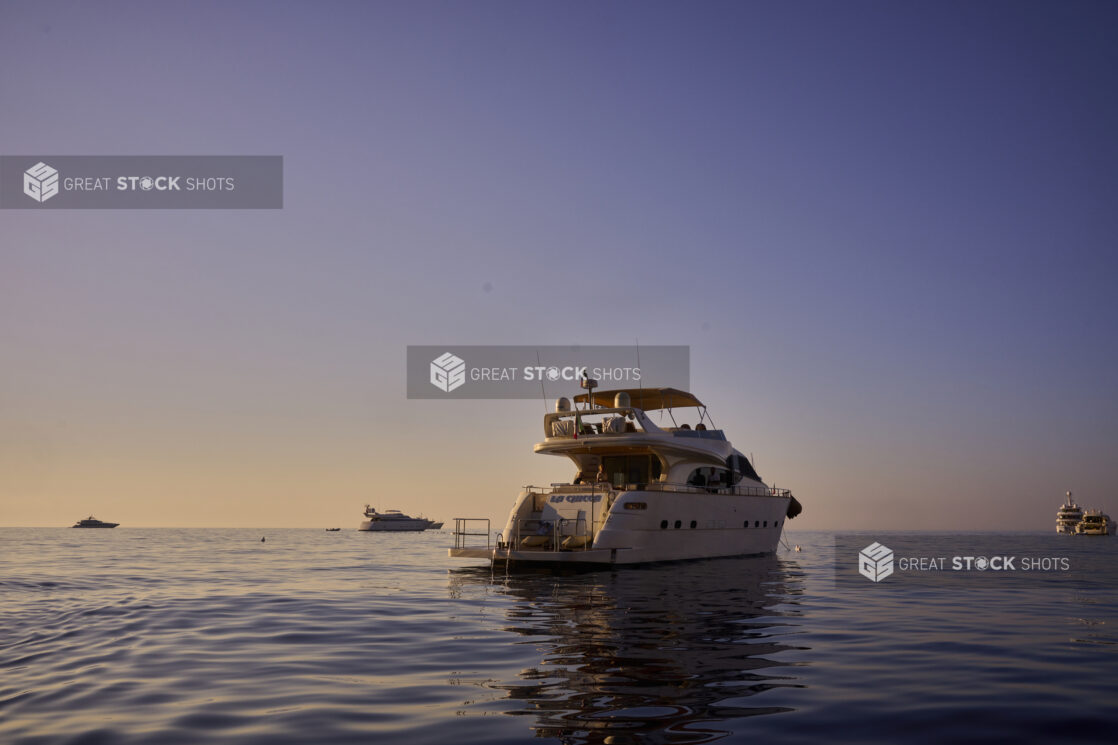 View of a yacht on the water with other yachts and boats in the background