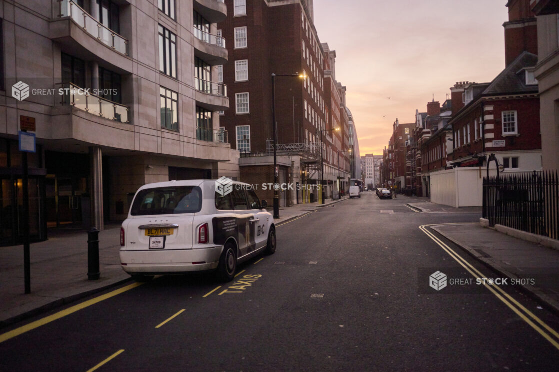 View of a street in London, England with a taxi, buildings and other vehicles