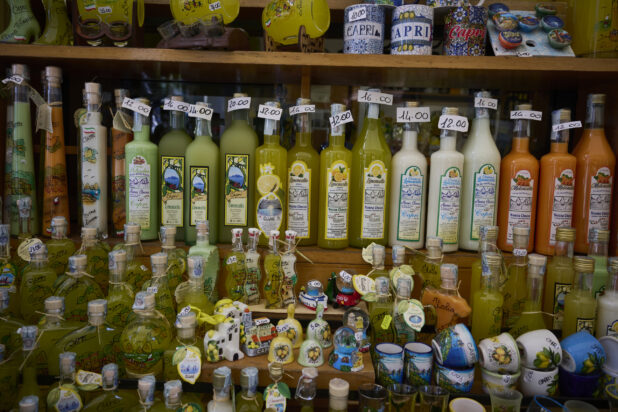 Shelves with colourful souvenirs and bottles of liqueur in a souvenir shop in Capri, Italy