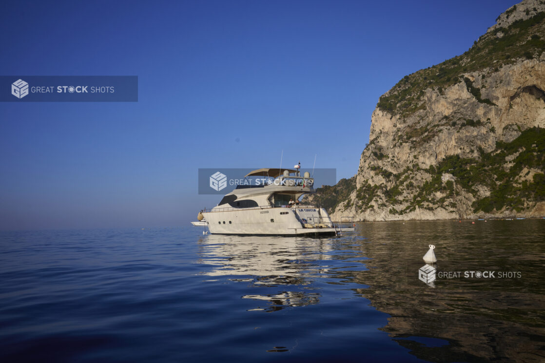 View of a yacht on the sea beside a mountainside