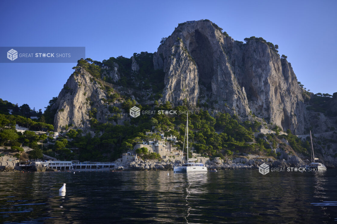 View of a mountain side, boats and village from the sea in the Mediterranean