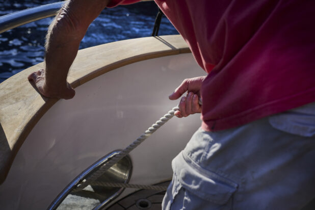 Man pulling in the ropes on a yacht