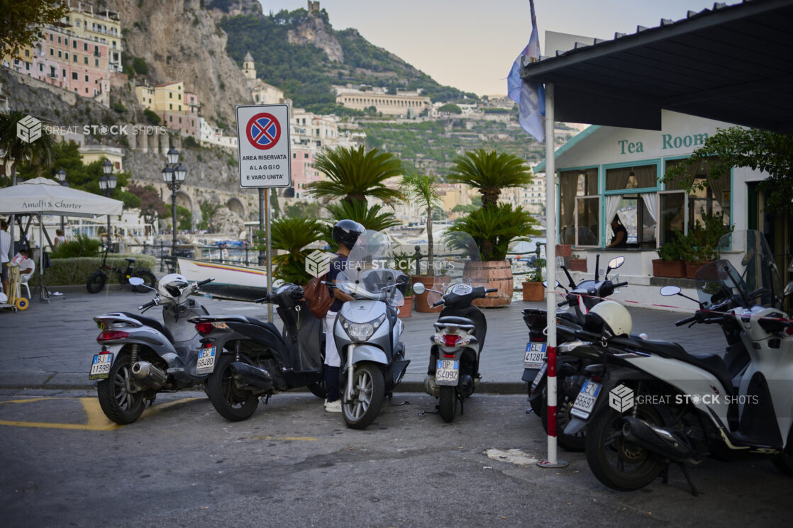 View of scooters, a cafe and hillside on the Amalfi coast, Italy