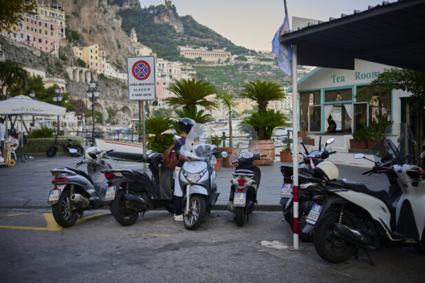 View of scooters, a cafe and hillside on the Amalfi coast, Italy