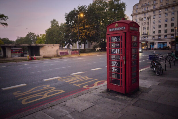 View of a London, England street with a telephone box on the sidewalk