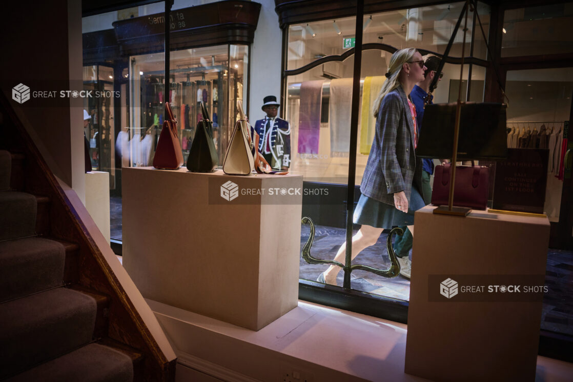 Inside looking out of a retail store in Burlington Arcade, London, England, people walking by