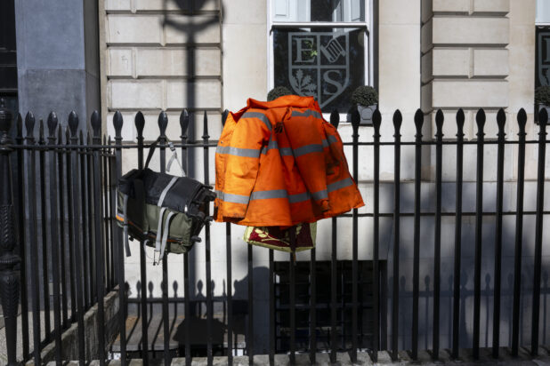 Orange jacket and bag Hanging on wrought iron fence
