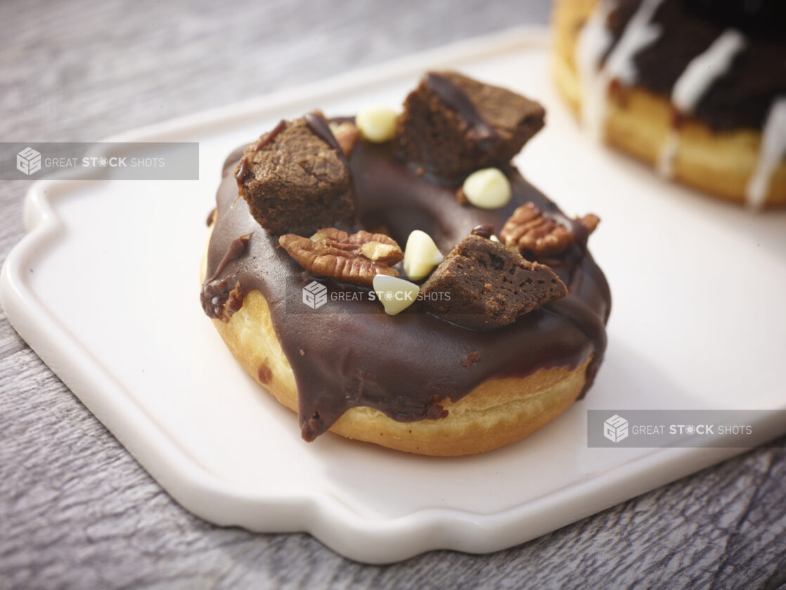 Brownie donut on a white patter on a grey wooden background