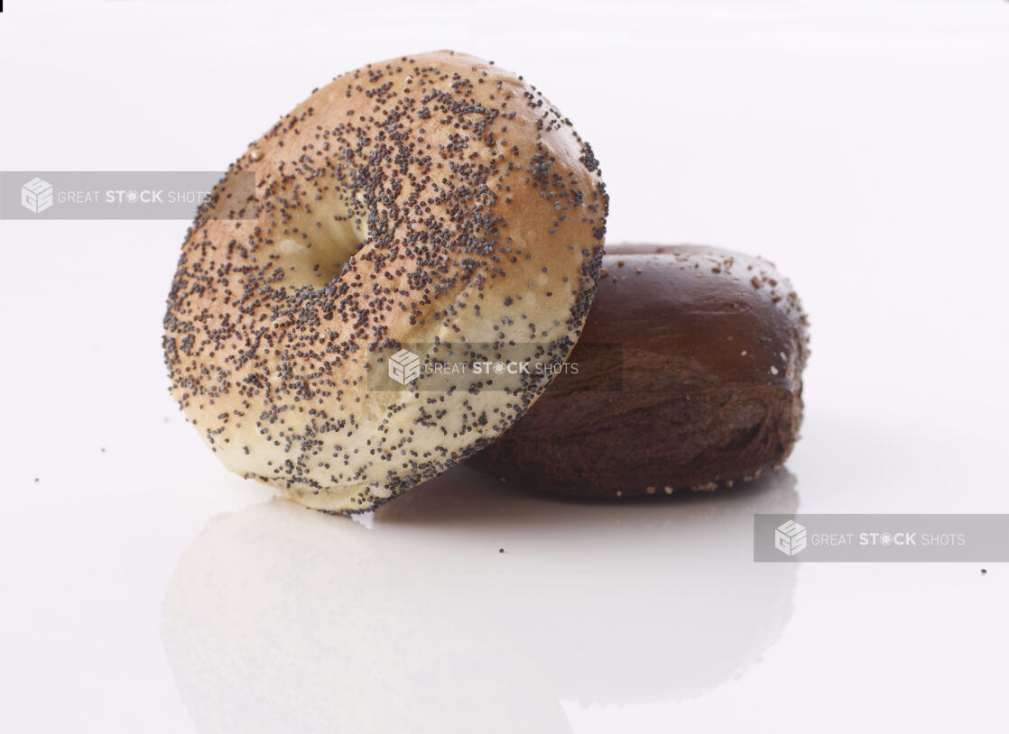 Poppy seed bagel lying on a pumpernickel bagel