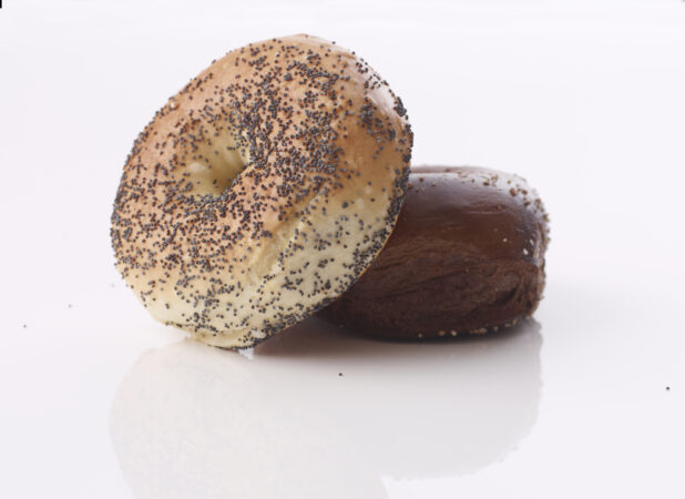 Poppy seed bagel lying on a pumpernickel bagel