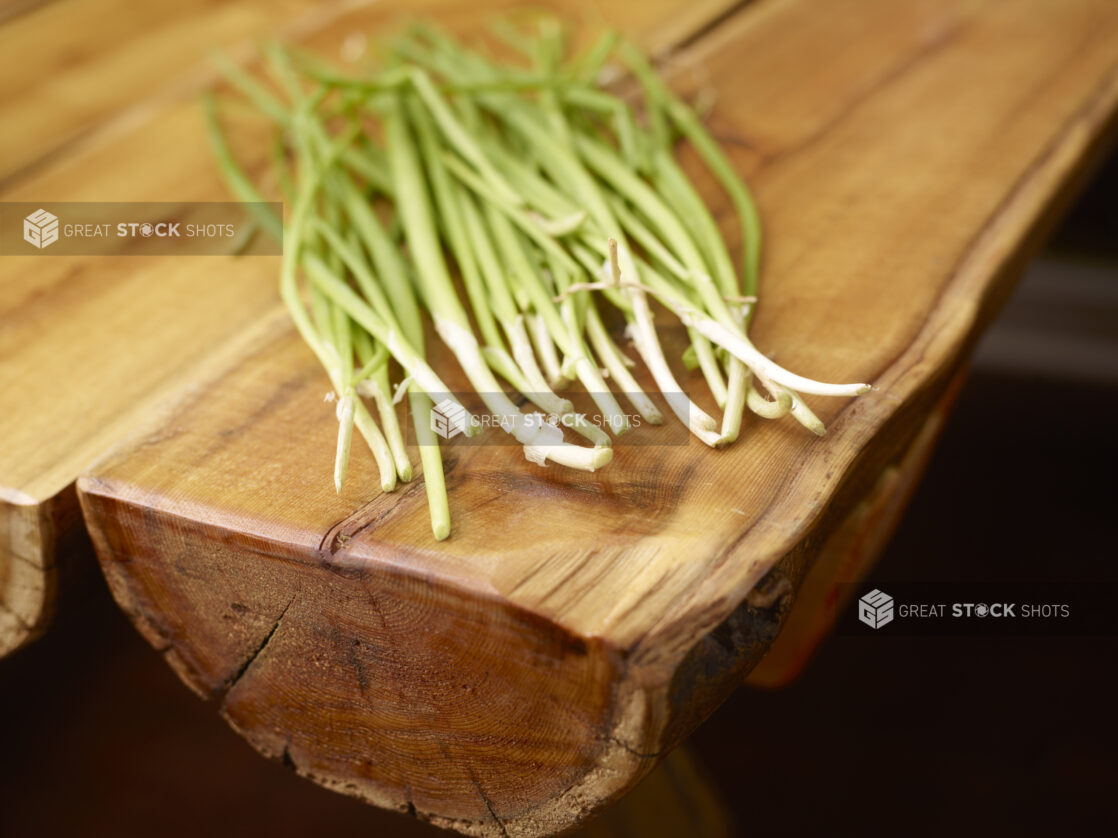 Whole Fresh Green Onion Stalks on Wooden Table with Bokeh Effect