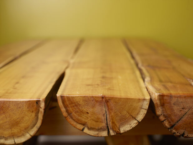Wood Panelled Table Against Green Background with Bokeh Effect