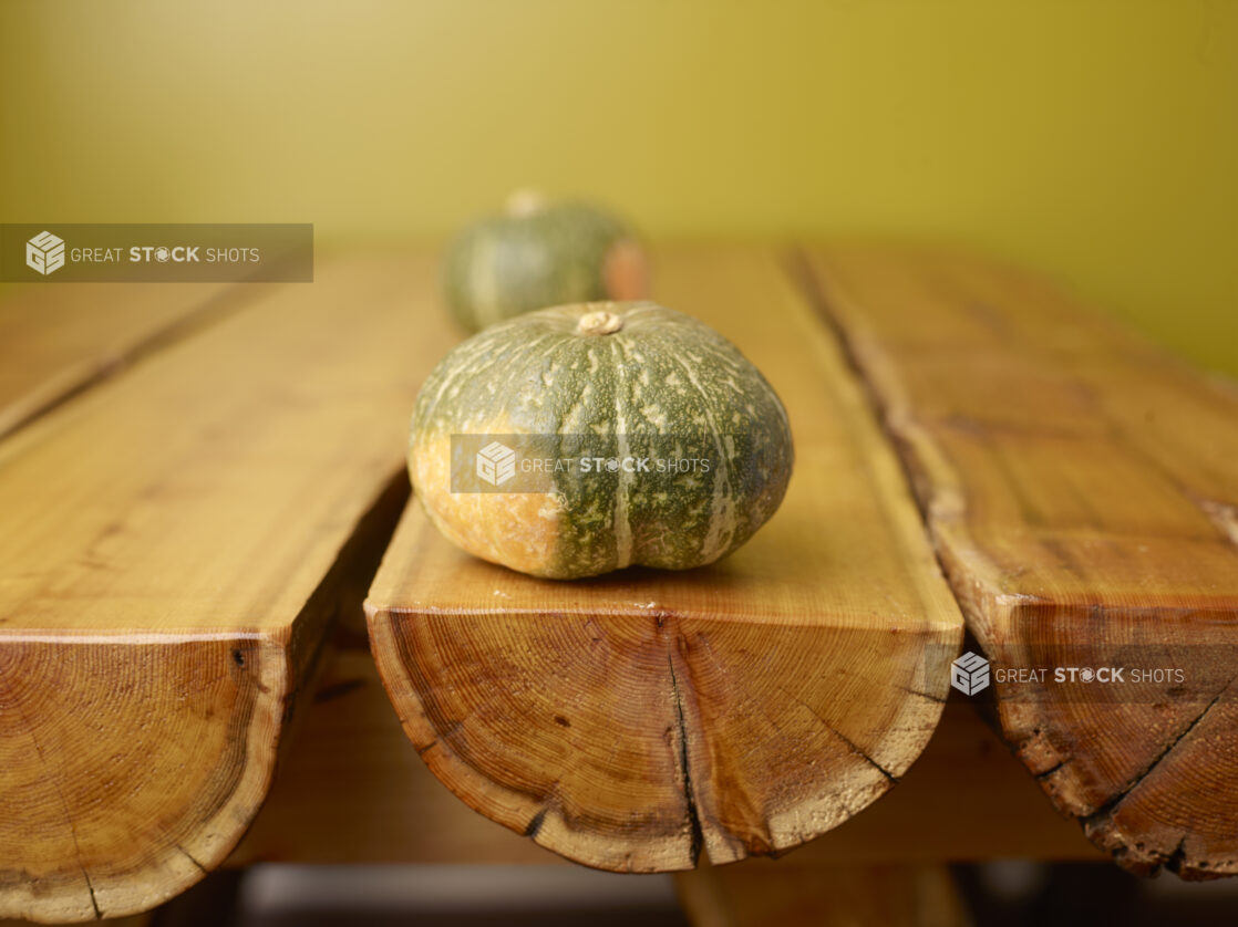 Whole Pumpkin on Wooden Table with Green Background and Bokeh Effect