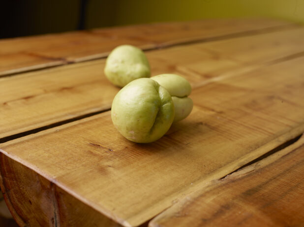 Whole, Raw, Jamaican Cho Cho or Chayote or Gourds on a Wooden Table With Bokeh Effect