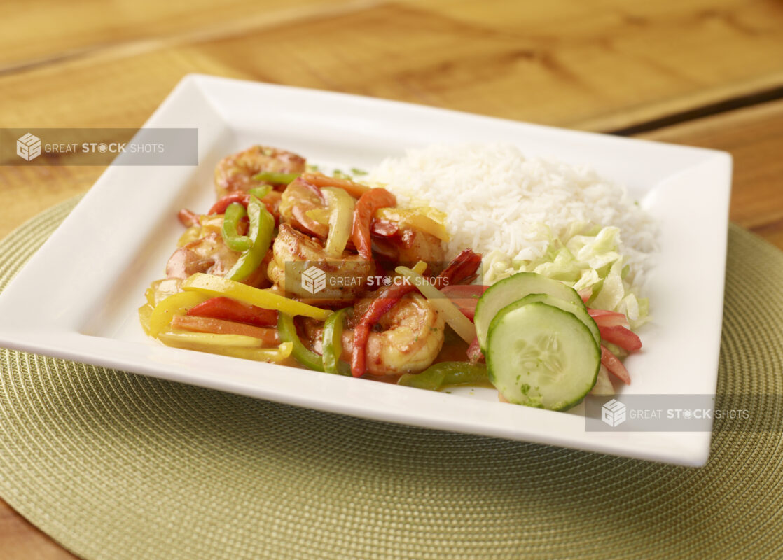 Caribbean Shrimp and Pepper Dinner with a Side of White Rice and Salad on a Square White Plate on a Wooden Table