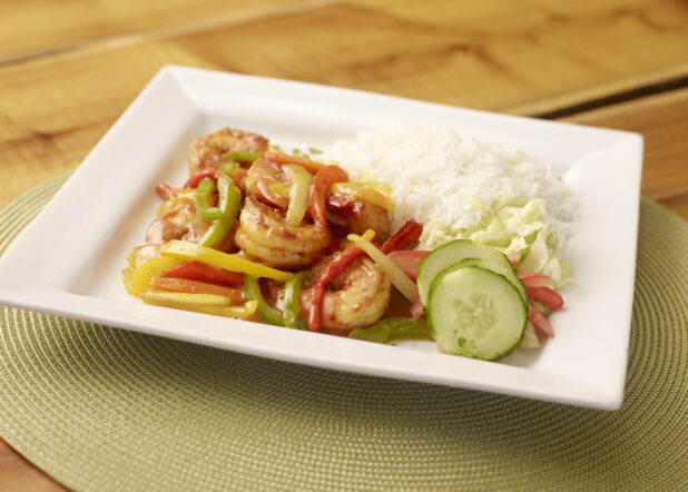 Caribbean Shrimp and Pepper Dinner with a Side of White Rice and Salad on a Square White Plate on a Wooden Table