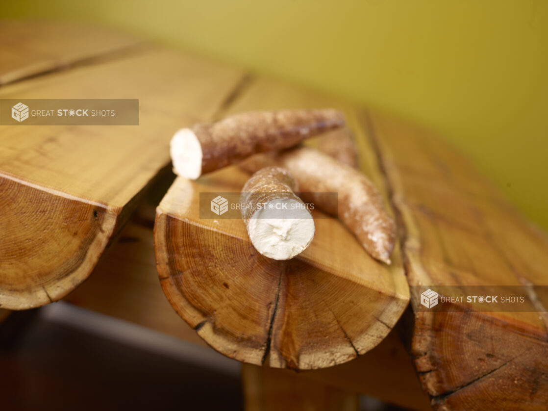 Raw Cassava Root on Wooden Table with Green Background and Bokeh Effect - Variation