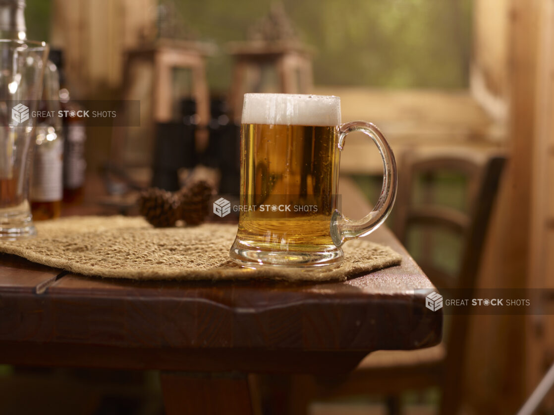 Close Up of Glass Stein of Draught Beer on a Woven Placemat and Wooden Table in an Indoor Setting