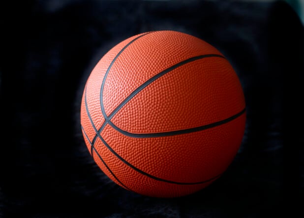 Orange and Black Basketball Ball Isolated Against a Black Background