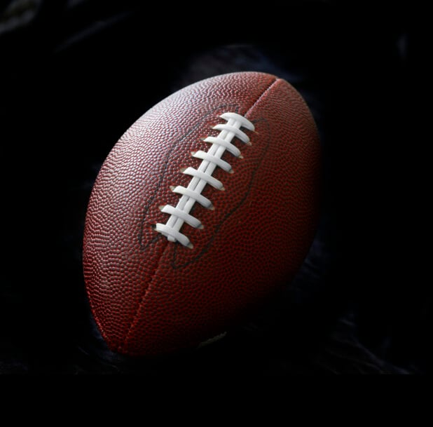 Standard American Football Isolated Against a Black Background