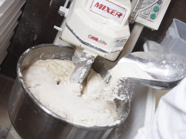 Person Adding Flour to Professional Pizza Dough Mixing Machine - Variation