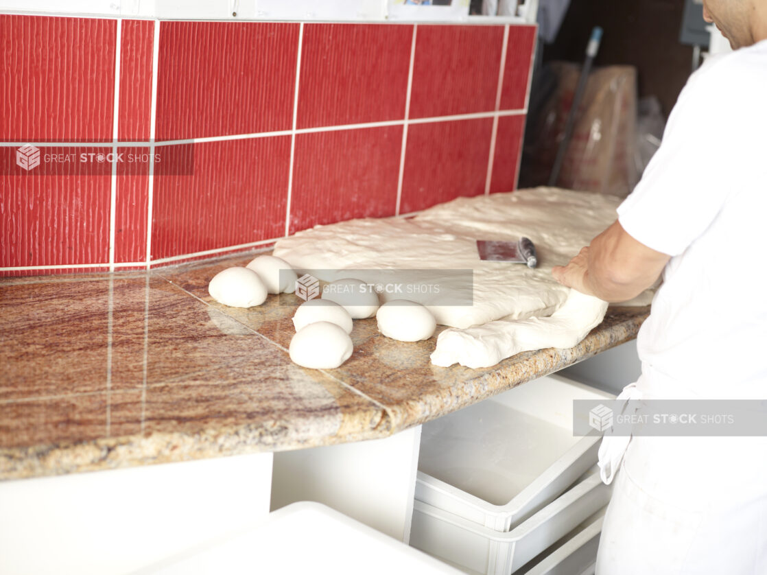 Pizza Chef preparing Pizza Dough in Restaurant Kitchen Setting