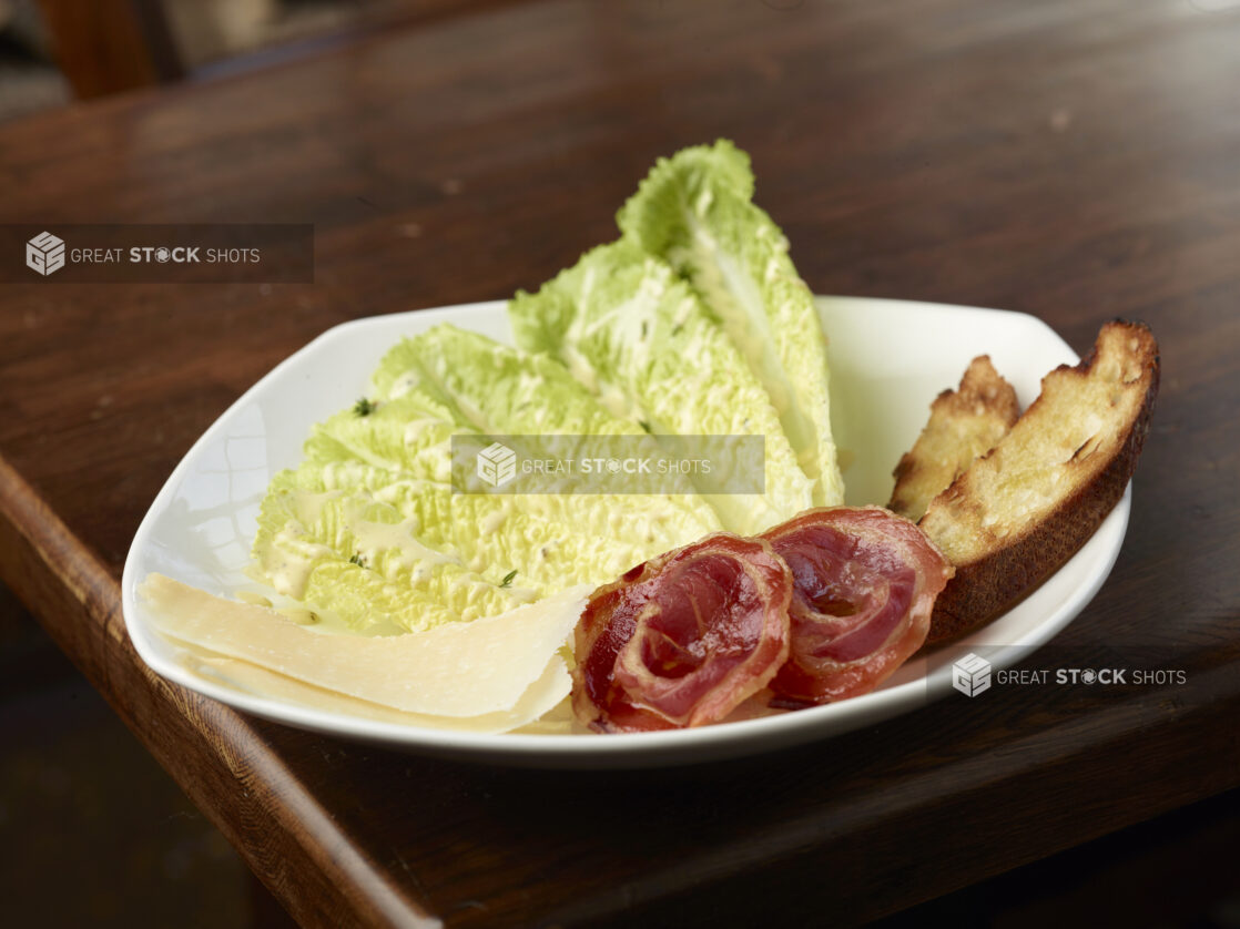 Deconstructed Caesar Salad on a White Plate in a Restaurant Table Setting