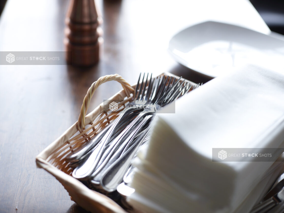 Forks in a Wicker Basket with Napkins on a Restaurant Table Setting