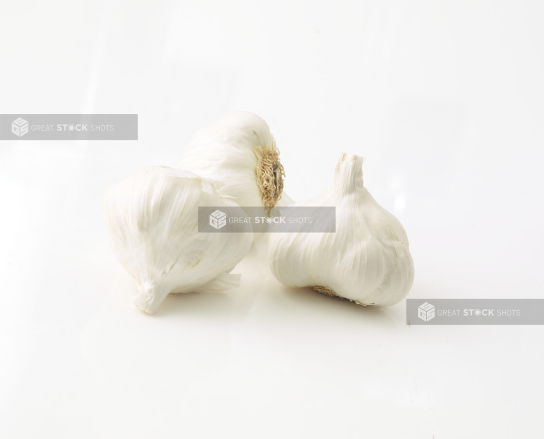 3 whole garlic bulbs in a close up view on a white background