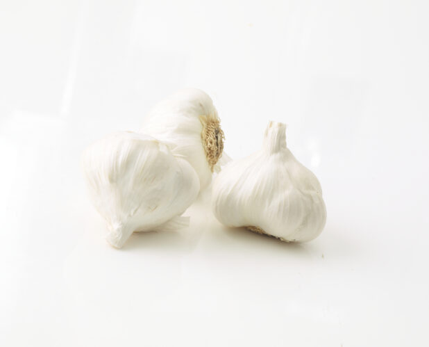 3 whole garlic bulbs in a close up view on a white background