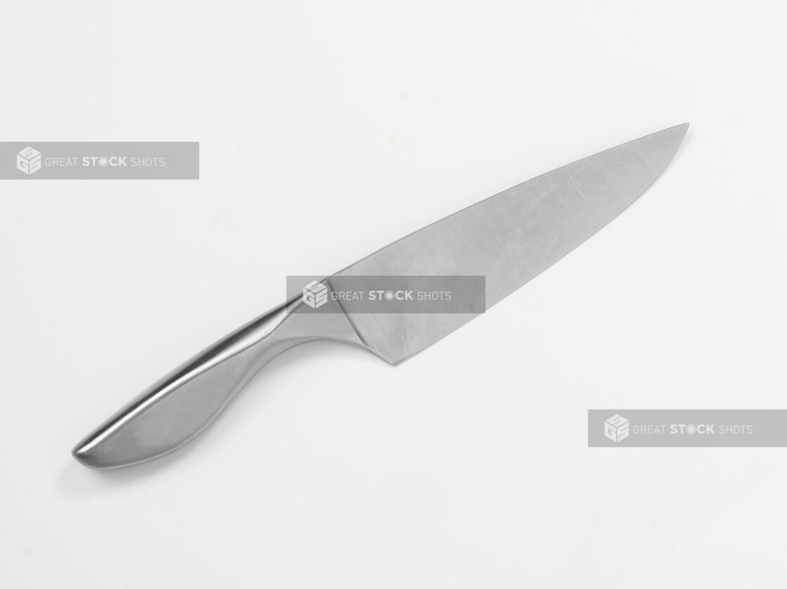 One-piece steel chef's knife on white background, close-up