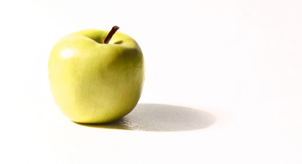 A Granny Smith apple on a white background