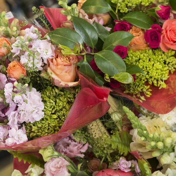 Close Up of Assorted Floral Bouquets Wrapped in Red Cellophane in a Florist or Retail Store Setting