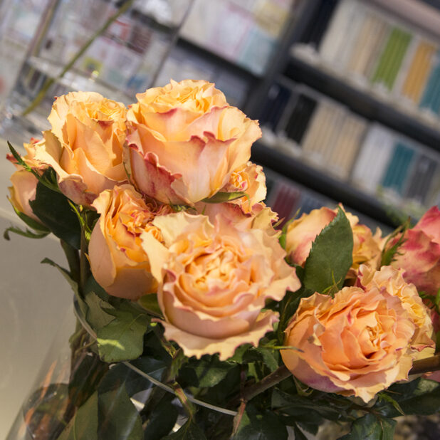 Arrangement of peach-coloured roses in a glass vase, close-up