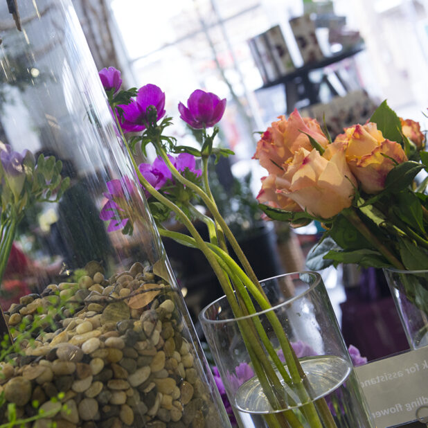 Tall glass vases of flowers and decorative stones for flower arrangement