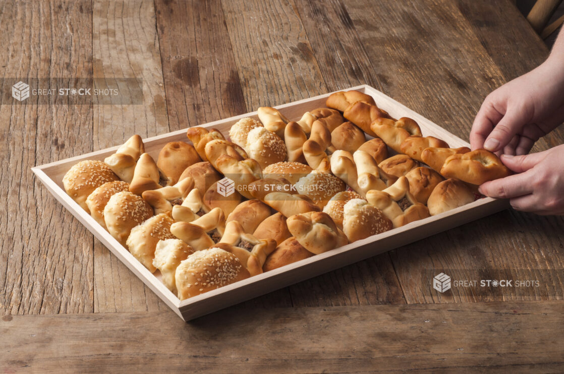 Large Middle Eastern Savoury Pie Platter (zaatar, safeeha, fatayer) in a Rectangular Wooden Serving Tray for Catering on a Wooden Table