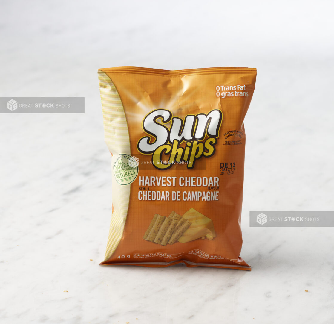 Individual bag of Harvest Cheddar Sun Chips on marble background