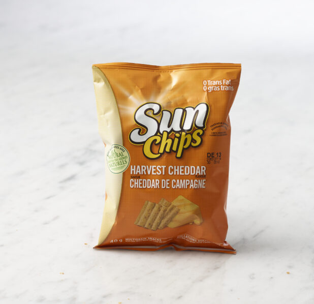 Individual bag of Harvest Cheddar Sun Chips on marble background