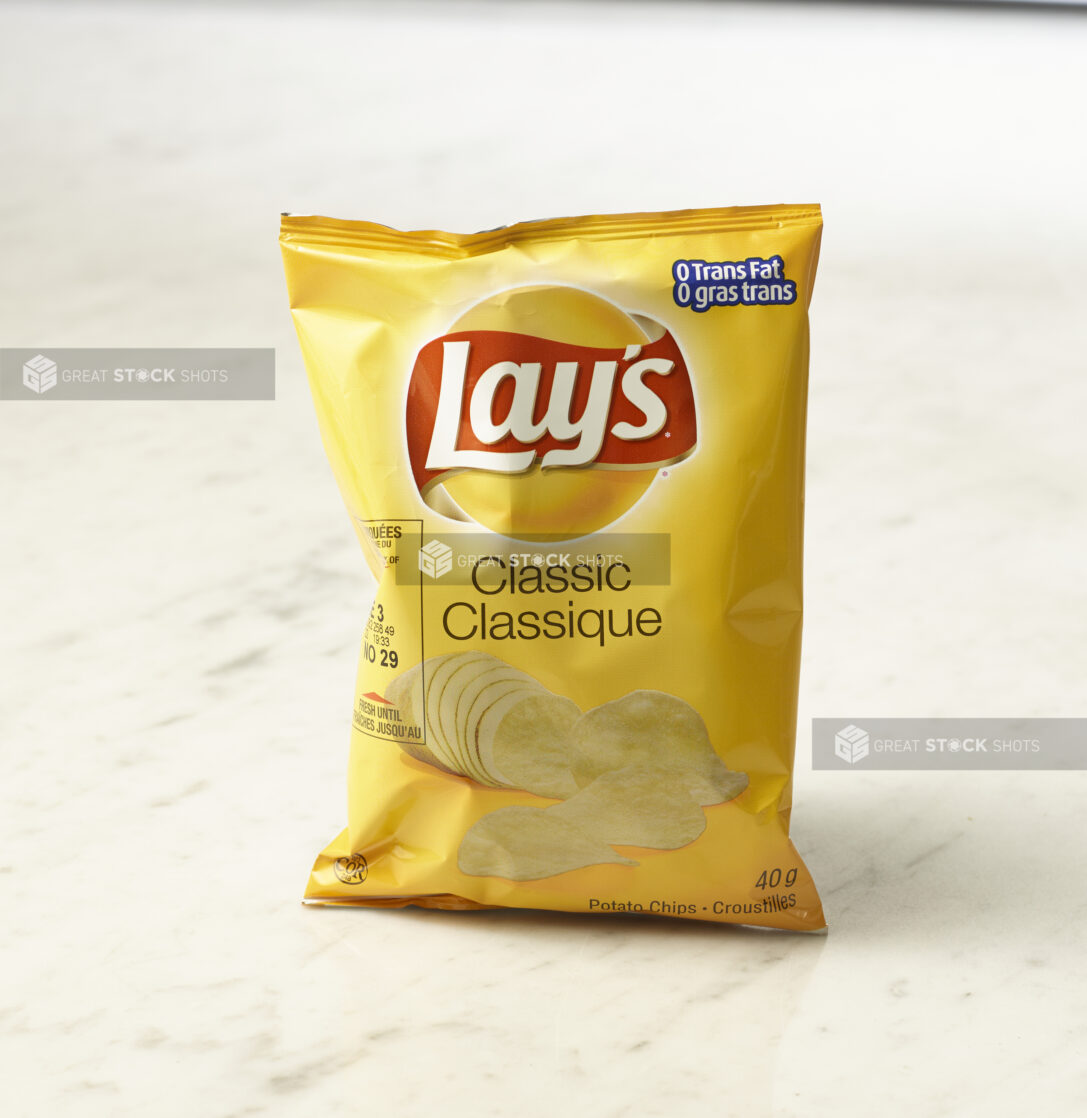 Individual bag of Lay's classic chips on marble background