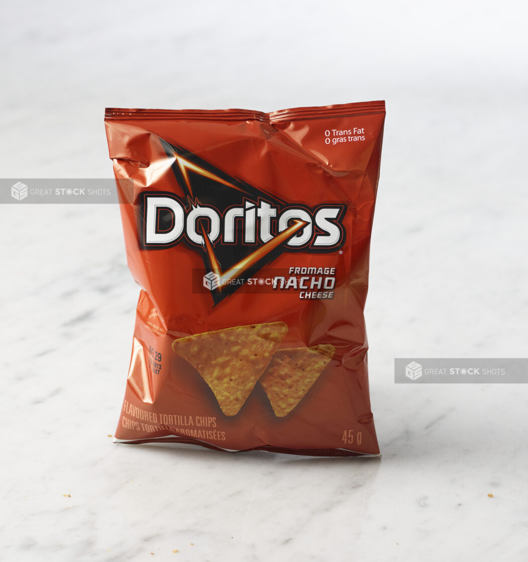 Individual bag of Nacho flavoured Doritos on marble background