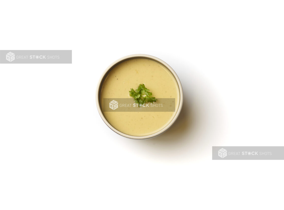 Overhead View of a Bowl of Lentil and Swiss Chard Vegan Soup with a Fresh Parsley Garnish, on a White Background for Isolation