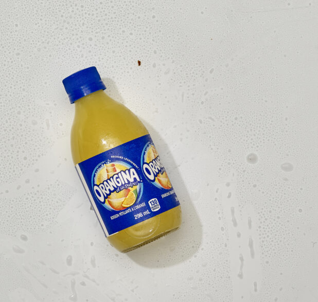 Overhead View of Orangina Sparkling Orange Beverage in a Glass Bottle, on a White Background for Isolation